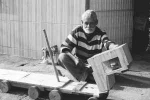 Artisan façonnant un jouet en bois à la main, illustrant la traçabilité du bois et les labels FSC PEFC pour les jouets en bois