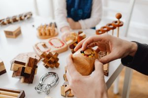 Mains posant une pièce de puzzle en bois découpée à la main