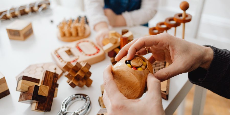 Mains posant une pièce de puzzle en bois découpée à la main